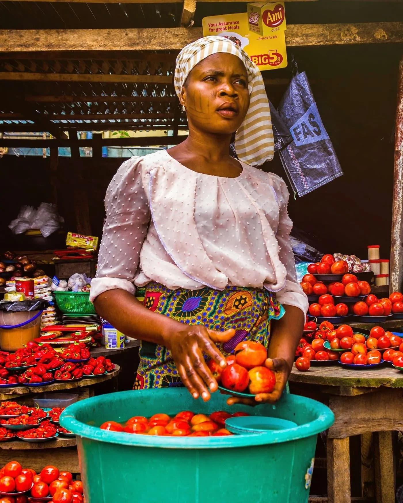 Vendeuse tenant des tomates sur son étal au marché