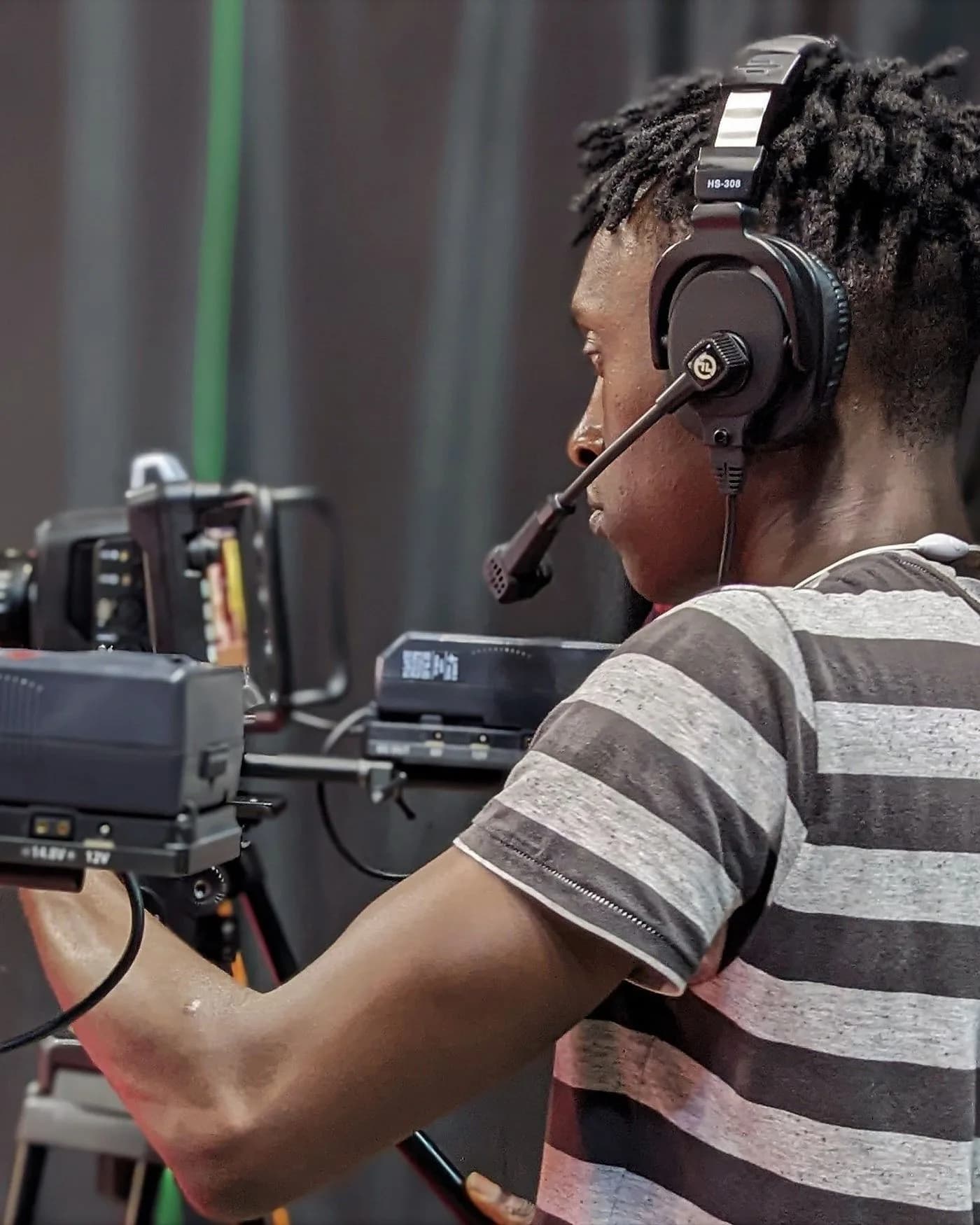 Cadreur derrière sa caméra et ses moniteurs dans un studio de production